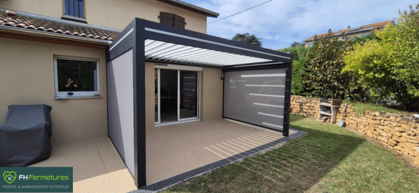 Pergola bioclimatique aluminium anthracite avec store zip et terrasse composite installée à Trévoux (01) par FH Fermetures
