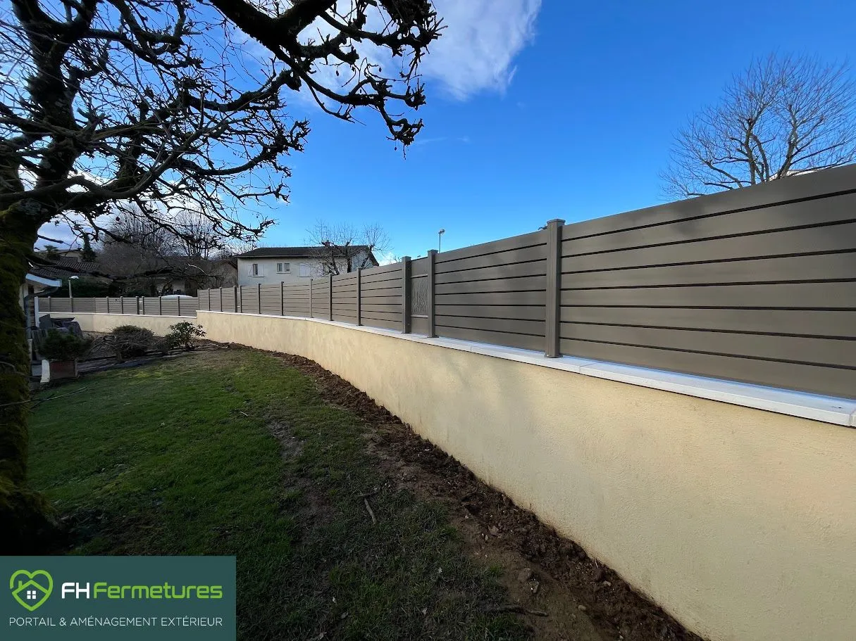 Clôture aluminium lames persiennes gris taupe avec panneaux motifs laser installée sur muret à Ars-sur-Formans (01) par FH Fermetures