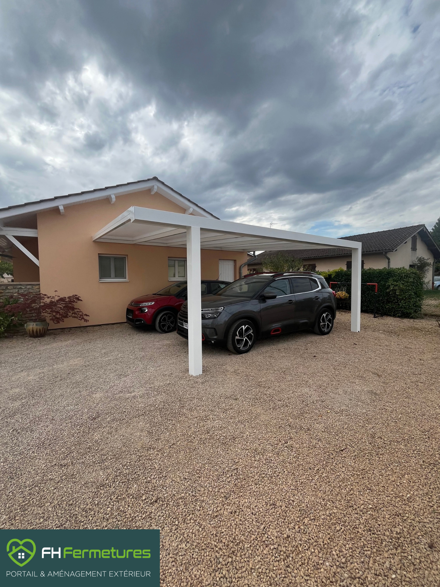 Carport alu adossé blanc avec poteau déporté abritant deux voitures à Grièges (01) par FH Fermetures