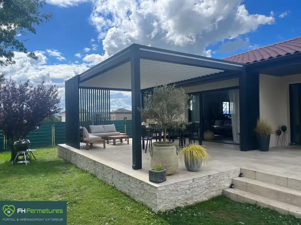 Pergola bioclimatique à fleur de façade avec boucliers design installée à Saint Didier de Formans (01) par FH Fermetures