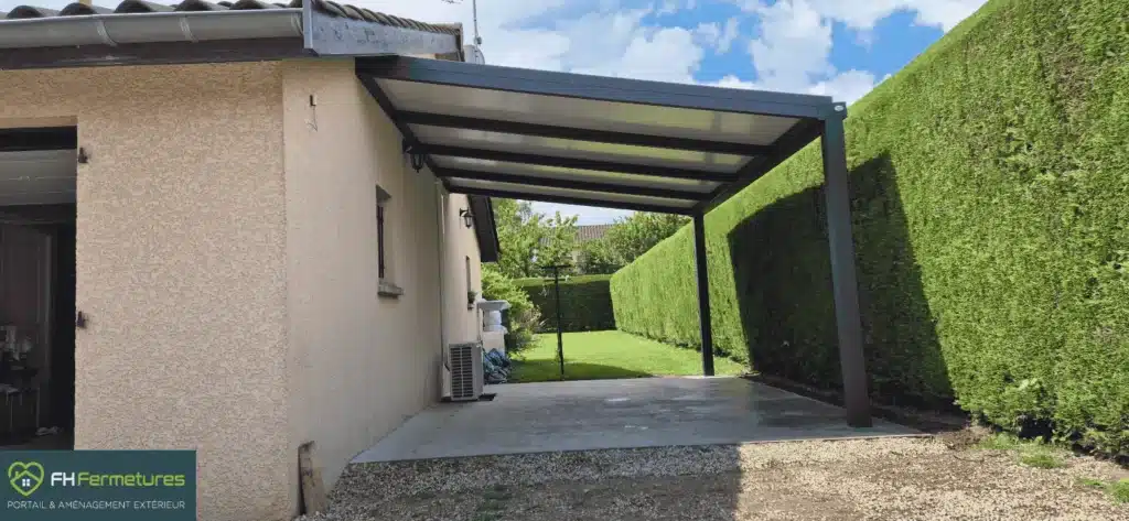 Carport aluminium anthracite adossé à la façade sur deux poteaux avec toiture panneau sandwich installé à Romanèche-Thorins (71) par FH Fermetures
