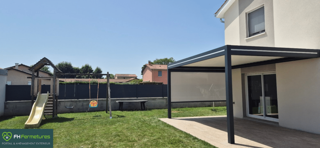 Pergola bioclimatique aluminium anthracite avec store latéral installée sur terrasse bois à Quincieux (69) par FH Fermetures