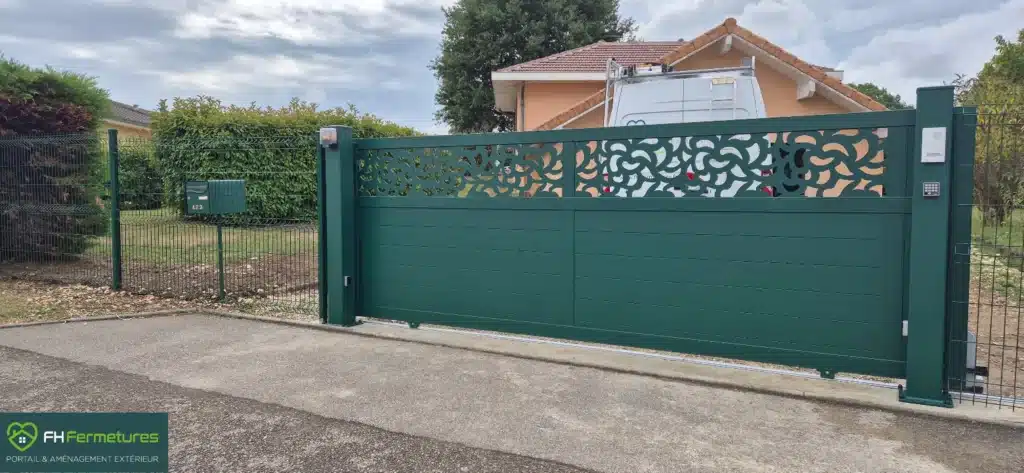 Portail coulissant aluminium vert RAL 6005 motif pétale gamme Mosaic KSM avec piliers aluminium et interphone installé à Saint-Denis-lès-Bourg (01) par FH Fermetures